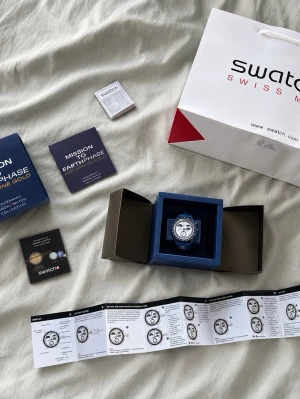 Omega x Swatch Mission to Earthphase Moonshine Gold -  Säljer en ny/oanvänd klocka i riktigt fint skick. Blå modell från Bioceramic MoonSwatch Collection. Full set med box, påse, papper, manual och allt som syns på bilden. Perfekt för samlare eller vardagsbruk.  Skickas snabbt och säkert. DM:a vid frågor eller för fler bilder.