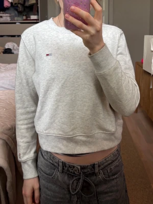 Ljusgrå sweatshirt från Tommy Hilfiger - Ljusgrå sweatshirt från Tommy Hilfiger i mjukt bomullsmaterial.