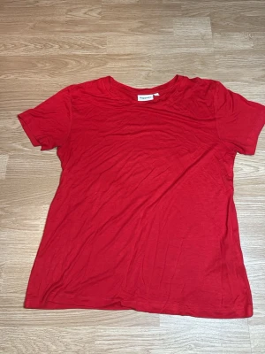 Röd basic t-shirt från Kappahl - En enkel röd t-shirt från Kappahl i mjuk bomull. T-shirten har rund halsringning och korta ärmar. I storlek S 