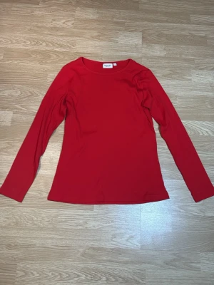 Röd ribbad långärmad topp Kappahl - En röd långärmad topp från Kappahl i ribbad bomull. I storlek L