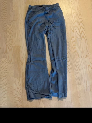 Blå linnebyxor med resårmidja - Snygga blå linnebyxor med avslappnad passform och resår i midjan. Byxorna har raka ben och sidfickor, perfekta för en chill och stilren look. Materialet är tunt och luftigt linne som ger en skön känsla hela dagen.