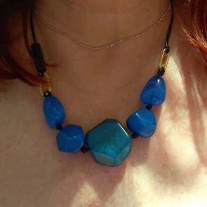Bohemiskt halsband  - Bohemiskt halsband med blå stenar som är justerbart.  Material ABS. Storlek 46-55 cm. Ej använt.