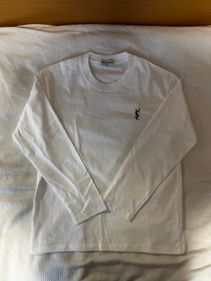 Vit långärmad tröja från Saint Laurent - Bra testad, helt ny! 50cm, 67cm höjd. Kom med bud och frågor! Kommer med påse och tag.