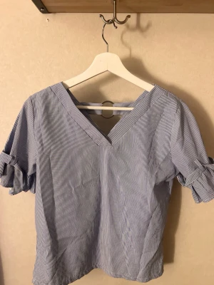 Blårandig blus med knytärmar - Köptes i Thailand därför vet jag inget märke på den & de står tyvärr ingen storlek. Men jag skulle säga att den passar XS-S!