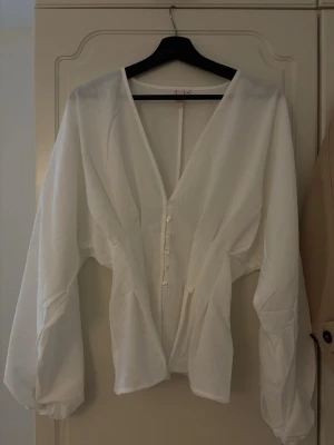 Vit blus - Så snygg blus från Nelly som är helt slutsåld! Är aldrig använd! Absolut inga defekter! 💕