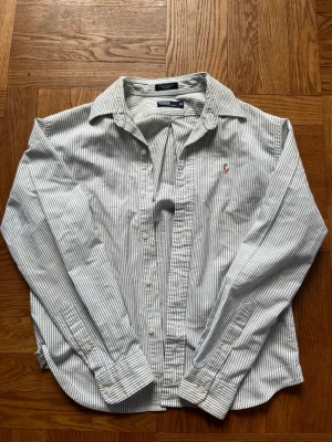 Randig skjorta från Ralph Lauren - Randig skjorta från Ralph Lauren. Tröjan är i barnstorlek (20) passar XS i herrstorlek. Mycket gott skick, skriv vid eventuella funderingar😁