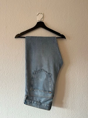 Slitna ljusa jeans - Relaxed fit ljusa jeans från H&M i storlek 34/34. Slitna från användning nere vid skorna och på fickor. Bidrar till karaktären