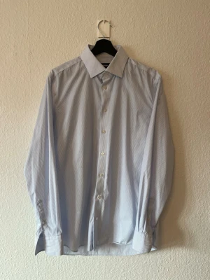 Pin stipe skjorta blå/vit från Dressmann - Vit tunn blårandig skjorta från dressmann storlek L-slimfit. 100% bomullsskjorta och strykfri 