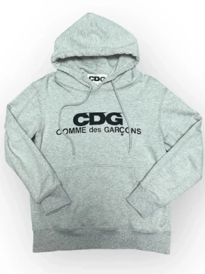 Comme des Garçons (CDG) Hoodie - Klassisk CDG-hoodie med tryck framtill. Clean design och bekväm passform, perfekt som vardagsplagg. OBS: Har ett litet hål på insidan (bild 4), Passar lite smalare än S Skick: 9/10 Pris kan diskuteras 📦