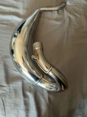 Kromad avgaskrök till moped - Säljer en kromad avgaskrök till moped eller cross. Den har en böjd, rundad form och är tillverkad i metall med blank finish. Perfekt för dig som vill uppgradera eller byta ut din nuvarande avgaskrök.