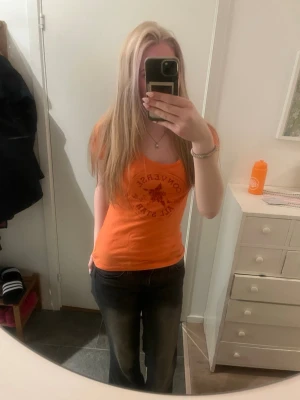 Orange Converse t-shirt med tryck - Snygg orange t-shirt från Converse med klassiskt All Star-tryck framtill