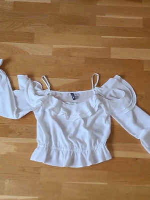 Topp H&M off shoulder  - Off shoulder topp med volanger från H&M i storlek 36