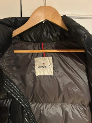 Dunjacka från moncler - Svart pufferjacka säljes då jag ej använder den längre och vill bli av med den. Har ett minimalt hål inuti ena fickan som inte syns.