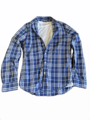 Gant flanellmönster - Snygg blå och vit rutig skjorta med klassisk krage och knäppning framtill. Skjortan har långa ärmar och är tillverkad i mjuk bomull, perfekt för en avslappnad och trendig look. Passar dig som gillar tidlös stil och vill ha något bekvämt.