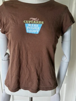 Brun tshirt med tryck - Brun tshirt med tryck bak och fram med material i bomull. Säljer pga att den inte används. Storleken kan upplevas som s/m💓