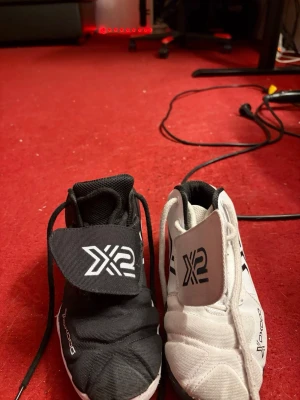 Oxdog målvaktsskor svart och vit - Oxdog Målvaktssko X2 är en pro-nivå målvaktssko som är byggd för snabba rörelser, maximalt skydd och långvarig hållbarhet – designad för elitprestanda. Denna sko är speciellt framtagen för innebandymålvakter som kräver bästa möjliga prestanda på planen. Den höga passformen och hållbarheten gör att skon sitter perfekt på foten samtidigt som den klarar av tuffa tag under intensiva matcher. 