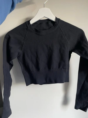 Kort träningströja - Kroppad/kort svart träningströja med långa ärmar från Stadium. Bra skick!