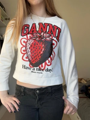 Vit sweatshirt med jordgubbstryck Ganni - Cool vit sweatshirt från Ganni med stort jordgubbstryck och texten 'Have a nice day! Please recycle' framtill. är min favorit men säljer pga att den blivit lite liten för mig😔 Tröjan har långa ärmar, rund halsringning och croppad passform. Perfekt statementplagg för dig som gillar färgglada prints. Har en liten fläck vid nedre kanten men inga sminkfläckar eller hål❤️ På tveka inte vid frågor eller bud❤️