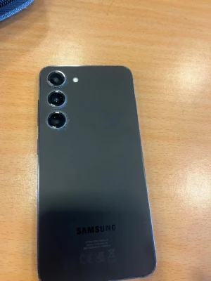 Samsung Galaxy S23 svart Android-telefon - Snygg svart Samsung Galaxy med stilren design och tre kameror på baksidan. Telefonen har rundade hörn, glasbaksida och en stor skärm på framsidan. Perfekt för dig som gillar Android och vill ha en modern mobil med bra kamera.