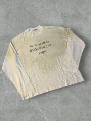 Vit långärmad  Acne Studios longsleeve | M - Vit långärmad topp från Acne Studios med tryck 'STOCKHOLM 1996' på framsidan. Klassisk rund halsringning och rak passform. Perfekt för dig som gillar minimalistisk stil och ikoniska svenska märken.
