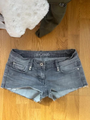 Grå jeansshorts från Pimkie - Säljer ett par grå jeansshorts från Pimkie med låg midja och fransiga benslut.  I storlek xs/s, står 36 i shortsen 💕 Klassisk femficksmodell med knapp och dragkedja framtill. Perfekta för sommaren och har en snygg, avslappnad look. 