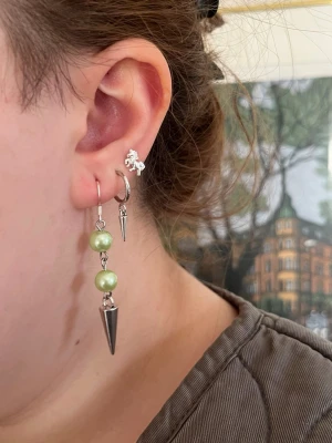 Gröna handgjorda pärlörhängen med nitar  - Jag skapar dessa smycken utav utvalda pärlhalsband från secondhand – ett medvetet val för att ge vackra material ett nytt liv.  Eftersom pärlorna är återbrukade kan små märken eller färgskiftningar förekomma på t.ex. metallen. Undvik kontakt med vatten för att bevara smyckena så fina som möjligt. Alla örhängen är handgjorda och säljs i par 💖🫶🏻⚜️