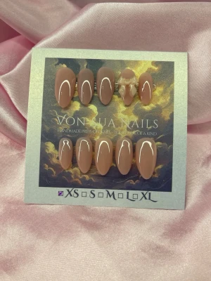 Bare (XS);Medium Almond - Snygga handgjorda press-on naglar i en pink nude färg med glans och en 3D-rosett på en nagel. Naglarna har en elegant medium längd av almondform och kommer i storlek XS: 14 mm, 11 mm, 11,5 mm, 10 mm, 8 mm . Perfekt för dig som vill ha en chic och trendig look.