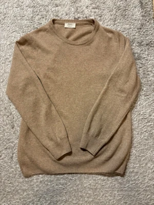 Beige stickad tröja - Säljer denna beiga stickade tröjan från Rinascente. Den är köpt från en galleria i Italien. Tröjan har rund halsringning, långa ärmar och ribbade muddar vid ärmslut och nederkant. Tröjan är använd endast ett fåtal gånger och är i princip helt ny. Den är perfekt nu för våren. Priset ej hugget i sten. Skriv vid frågor eller fler bilder.