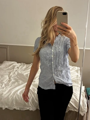 Blå vit randig skjorta dam - Super söt kortärmad skjorta med voulange. Randig i st 38, figursydd och passar snarare 34/36