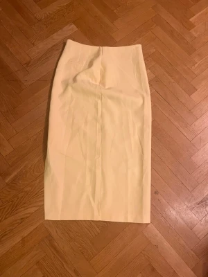 Ljusgul långkjol med slits - Snygg ljusgul långkjol med rak passform och slits på sidan. Kjolen har en minimalistisk design och är perfekt för dig som gillar stilrena plagg. Skriv gärna för mått! 💕