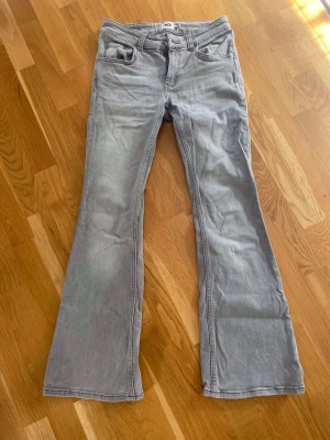 Ljusgrå bootcut jeans från H&M - Säljer ett par ljusgrå bootcut jeans från Lager 157. Jeansen har low boot och är i length short. 