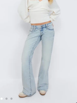 Ljusblå bootcut jeans från Gina Tricot - Säljer ett par ljusblå bootcut jeans från Gina Tricot helt nya med pris lappen kvar med snygg broderad detalj på bakfickan. Jeansen är låg midjade 