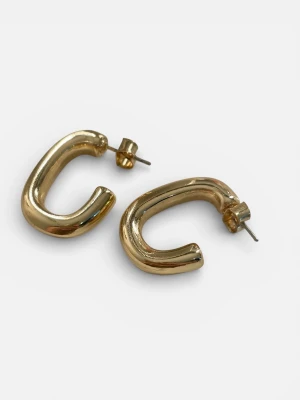 Chunky guldfärgade hoops örhängen - Säljer ett par chunky hoops örhängen i guldfärgad metall. De har en modern, rundad och öppen form som ger en cool och trendig look. Perfekta för att lyfta vilken outfit som helst med en touch av guld. Stift och lås i metall.