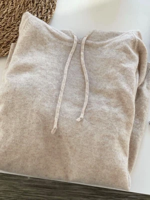 Beige hoodie från Davida i cashmere - Mysig beige hoodie från Davida i mjuk cashmere. Stilren hoodie i 100% cashmere. Otroligt bra kvalité och skitsnygg