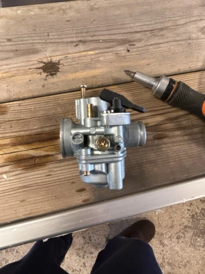  Division förgasare 17,5 mm  - Säljer en silverfärgad förgasare i metall med flera justerskruvar och anslutningar. Helt oanvänd 17,5 mm divison förgasare helt ny. Manuell choke helt ny. Ny kostade 599 