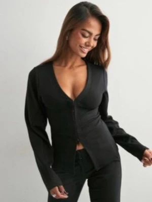 Svart v-ringad kofta/cardigan - Stilren svart kofta med v-ringning och  framtill. Modellen är croppad och har långa ärmar. Perfekt att matcha med både jeans och kjol för en trendig look.