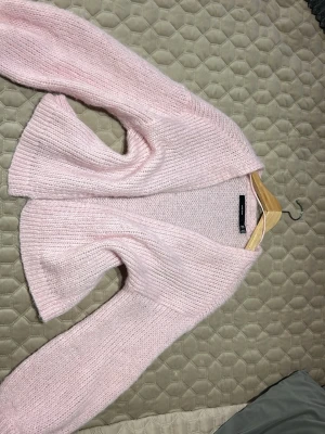 Ljusrosa stickad kofta från H&M - Mysig ljusrosa stickad kofta från Vero moda med öppen front och breda ärmar. Använd endast 1 gång. Storlek xs 