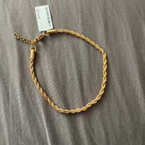 Guldfärgat rope-armband - Snyggt guldfärgat armband från Bearope med tvinnad rope-design och justerbar kedja. Armbandet är 3mm brett och har en klassisk karbinhake. Perfekt accessoar för att lyfta din stil med en elegant touch.