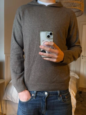 Brun hoodie i mjuk kashmir  - Säljer en stilren brun hoodie från Massimo dutti i mjuk kashmir. Hoodien har en klassisk huva, ribbade muddar vid ärmslut och nederkant samt en enkel, clean look utan tryck eller dragkedja. Perfekt för dig som gillar minimalistisk stil.