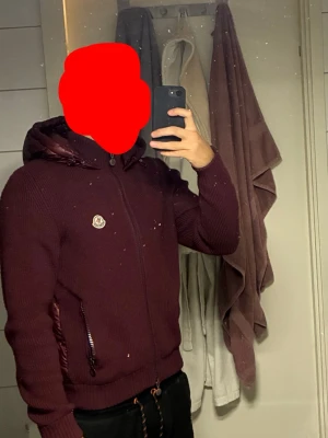 Snygg exklusiv Moncler cardigan  - Snygg exklusiv Moncler cardigan i vinröd. Denna färg och modell går ej att få tag på längre. Perfekt för dig som inte vill se ut som alla andra. Jackan är i storlek L men sitter mer som M. Jackan är självklart äkta, köpt på Merchsweden. Kvitto finns