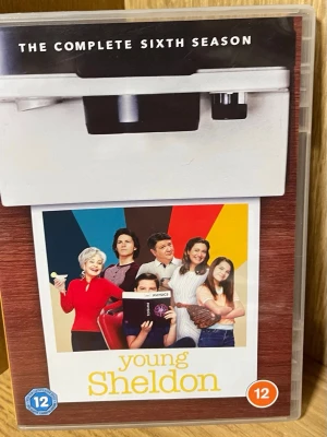 Young Sheldon Säsong 6 DVD - DVD-box med hela sjätte säsongen av TV-serien Young Sheldon. Omslaget har färgglad design med karaktärerna från serien och tydlig text. Innehåller 22 avsnitt, åldersgräns 12 år. Perfekt för dig som gillar komediserier och samlar på TV-boxar.