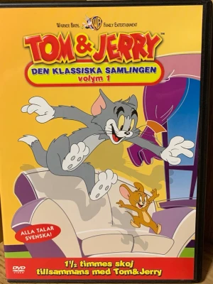 Tom & Jerry Den klassiska samlingen vol 1 DVD - DVD med Tom & Jerry: Den klassiska samlingen volym 1. Omslaget är gult med färgglada illustrationer av Tom och Jerry. Innehåller 1,5 timme tecknade avsnitt på svenska och engelska. Perfekt för dig som gillar klassiska tecknade serier.