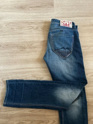 Mustang jeans - Säljer ett par blå jeans från Kelso Mustang med klassisk femficksmodell och snygga slitningar. Jeansen har raka ben och en cool detalj på bakfickorna. Perfekta till en avslappnad stil. Har bara använt 2 gånger. Storlek 31/34