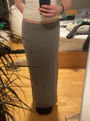 En stretchig grå maxi kjol  - Hej!! Jag säljer en grå maxi kjol från weekday. Det är stretchig och går hele vägen ner till fötterna, väldigt skön och sval!!