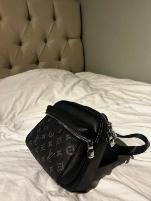 Louis Vuitton svart axelväska(Pris diskuteras) - Snygg svart axelväska från Louis Vuitton i klassiskt monogrammönster. Väskan har justerbar axelrem, silverfärgade dragkedjor och är tillverkad i tåligt canvasmaterial. Perfekt för dig som vill ha en stilren och praktisk väska med exklusiv känsla. Jag ska sluta med märkes kläder därför säljer den samt till jätte bra pris. 