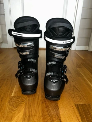 Svarta HEAD skidpjäxor med spännen - Säljer ett par svarta pjäxor från HEAD. Använda 2 vintrar totalt 2 veckor. Flex 90, storlek 26.5 250/255 mm 