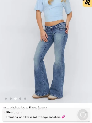 Blåa flare jeans från Gina - Snygga blåa flare jeans från Gina med låg midja och klassisk femficksdesign. Jeansen har en cool tvättad look och breda ben som ger en trendig siluett. Perfekta för dig som gillar 00-talsstil och vill ha ett par jeans som sticker ut.