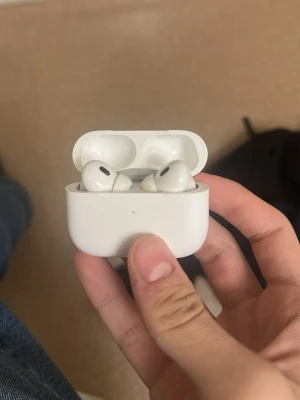 2 styckna Apple AirPods Pro med laddningsetui - Säljer 2 par vita Apple AirPods Pro med trådlöst laddningsetui. De har en stilren och kompakt design med rundade former och sitter bekvämt i öronen. Perfekta för musik, samtal och brusreducering. Laddningsetuiet är också vitt och smidigt att ta med.