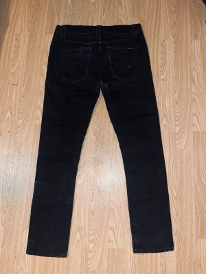  Snygga svarta jeans från Nudie Jeans - Säljer dessa snygga svarta jeans från Nudie Jeans i storlek 30/30. De är i fint skick, använda ett fåtal gånger. Inga hål . Material: 100% bomull. Perfekta för både vardag och fest.