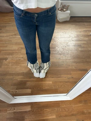 Mörkblå bootcut jeans med fickdetalj - Säljer ett par mörkblå bootcut jeans. Jag har sytt om dom till lite mer bootcut passform nedtill, med ett randigt tyg. Jag har även sytt om fickorna till en cool design. Jeansen har ett väldigt stretchigt denimtyg vilket ger en snygg och bekväm passform. (W är S, innebenslängd 80cm) 